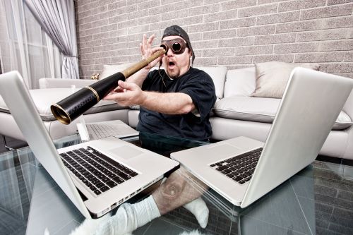 man looking at computer screens with telescope